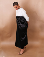 Woman wearing a black and white dress against a brown background