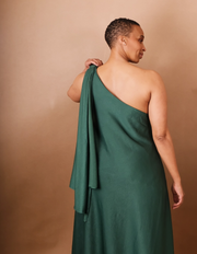 Woman wearing a green one-shoulder dress against a beige background - Anissa Mpungwe Atelier