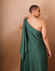 Woman wearing a green one-shoulder dress against a beige background - Anissa Mpungwe Atelier